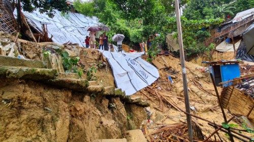 People carry umbrellas as they gather near a landslide affected area at the Balukhali refugee camp ... People carry umbrellas as they gather near a landslide affected area at the Balukhali refugee camp ...