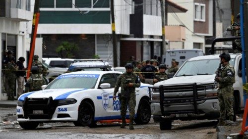 Members of the security forces stand guard outside a building amid an operation, where according to ... Members of the security forces stand guard outside a building amid an operation, where according to ...