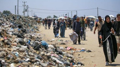 TOPSHOT - People walk on a street littered with rubbish in Khan Yunis on the southern Gaza Strip on ... TOPSHOT - People walk on a street littered with rubbish in Khan Yunis on the southern Gaza Strip on ...