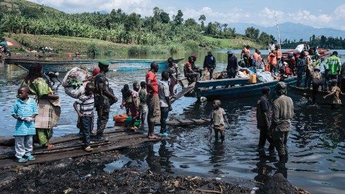 TOPSHOT - War-displaced people, local residents and a Congolese soldier set off for Goma on a ... TOPSHOT - War-displaced people, local residents and a Congolese soldier set off for Goma on a ...