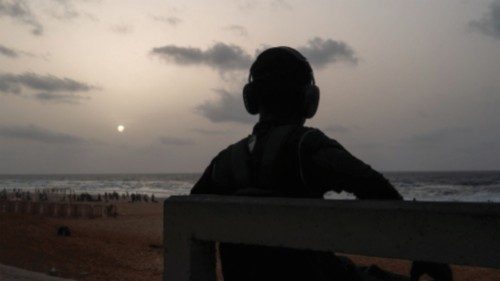 A man listens to music as he sits on a bench during sunset by the Yoff Beach in Dakar, Senegal July ... A man listens to music as he sits on a bench during sunset by the Yoff Beach in Dakar, Senegal July ...