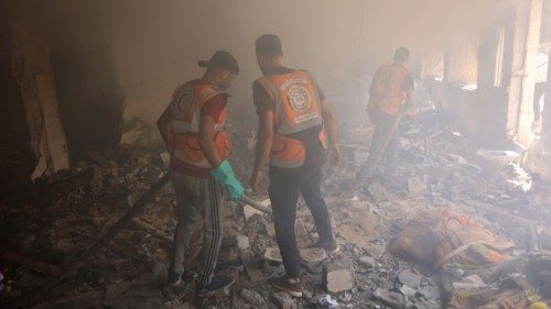 Palestinian civil defence workers douse the rubble and debris of the Latin Patriarchate Holy Family ... Palestinian civil defence workers douse the rubble and debris of the Latin Patriarchate Holy Family ...