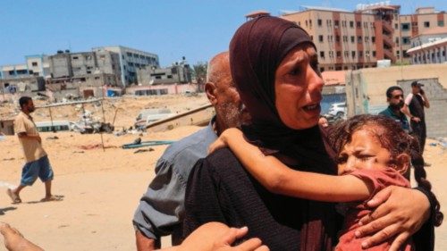 A Palestinian woman carries an injured child to the Nasser hospital in Khan Yunis on July 13, 2024, ... A Palestinian woman carries an injured child to the Nasser hospital in Khan Yunis on July 13, 2024, ...