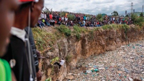 Crowds gather on the edge of an abandoned quarry to watch volunteers searching through a rubbish ... Crowds gather on the edge of an abandoned quarry to watch volunteers searching through a rubbish ...