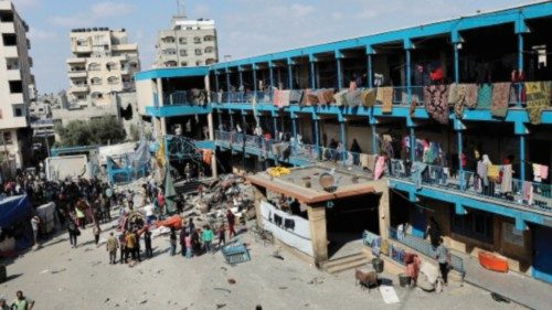 Palestinians gather at the site of an Israeli air strike on a UN school sheltering displaced people, ...