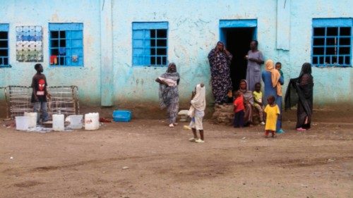 Displaced people stand outside a shelter at a displacement camp in Gedaref city in the east of ... Displaced people stand outside a shelter at a displacement camp in Gedaref city in the east of ...