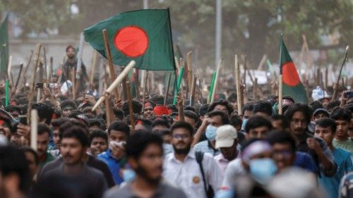 Anti-quota protesters march with Bangladeshi flags and sticks as they engage in a clash with ... Anti-quota protesters march with Bangladeshi flags and sticks as they engage in a clash with ...