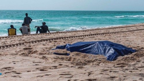 TOPSHOT - Bystanders stand near covered bodies of migrants who perished in a shipwreck off the coast ... TOPSHOT - Bystanders stand near covered bodies of migrants who perished in a shipwreck off the coast ...