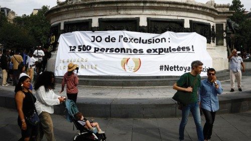People walk past a banner which reads 'Olympic Games of exclusion, 12,500 people expelled!' as ... People walk past a banner which reads 'Olympic Games of exclusion, 12,500 people expelled!' as ...