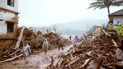 People walk past debris at a landslide site after multiple landslides in the hills in Wayanad, in ... People walk past debris at a landslide site after multiple landslides in the hills in Wayanad, in ...