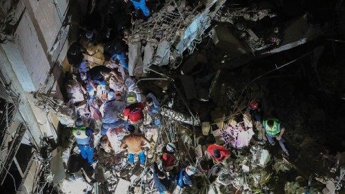 Rescuers search through the top floors of building destroyed following an Israeli military strike on ... Rescuers search through the top floors of building destroyed following an Israeli military strike on ...