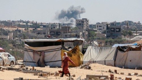 TOPSHOT - Smoke from Israeli bombardment billows in the background as a woman walks in Khan Yunis in ... TOPSHOT - Smoke from Israeli bombardment billows in the background as a woman walks in Khan Yunis in ...