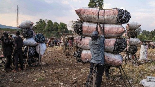 A merchant loads charcoal on his bicycle at the market, where internally displaced people trade ... A merchant loads charcoal on his bicycle at the market, where internally displaced people trade ...