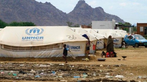 Sudanese already displaced by conflict, walk near tents at a makeshift campsite they were evacuated ... Sudanese already displaced by conflict, walk near tents at a makeshift campsite they were evacuated ...