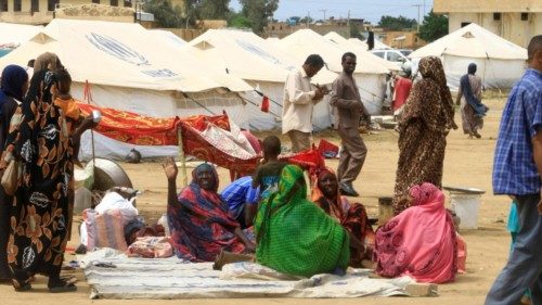 TOPSHOT - Sudanese already displaced by conflict, walk near tents at a makeshift campsite they were ...