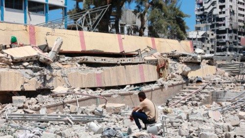TOPSHOT - A man looks at the debris after an Israeli strike on a school, housing displaced ... TOPSHOT - A man looks at the debris after an Israeli strike on a school, housing displaced ...