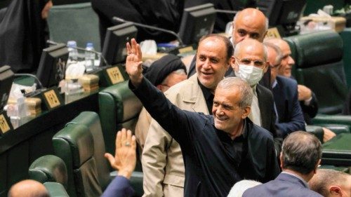 Iran's President Masoud Pezeshkian (C) greets parliament members after giving an address during a ...