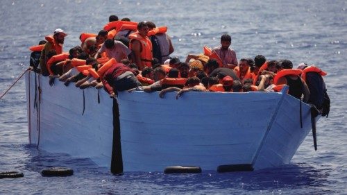 Migrants stand on a wooden boat near NGO Open Arms rescue boat 'Astral' in international waters ... Migrants stand on a wooden boat near NGO Open Arms rescue boat 'Astral' in international waters ...