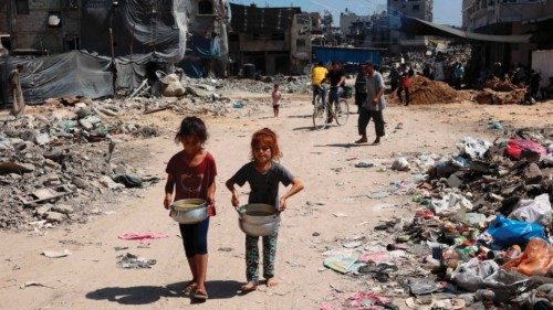 TOPSHOT - Palestinian children carry pots of soup near a food distribution point in the Jabalia ... TOPSHOT - Palestinian children carry pots of soup near a food distribution point in the Jabalia ...