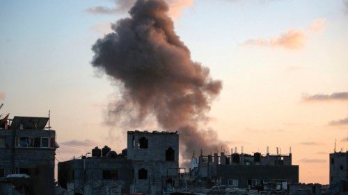 TOPSHOT - Smoke rises as Israeli troops target a building in the Nuseirat refugee camp in the ...