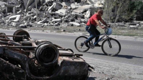 TOPSHOT - A man rides bicycle past the debris of a multi-storey building, destroyed few days earlier ... TOPSHOT - A man rides bicycle past the debris of a multi-storey building, destroyed few days earlier ...