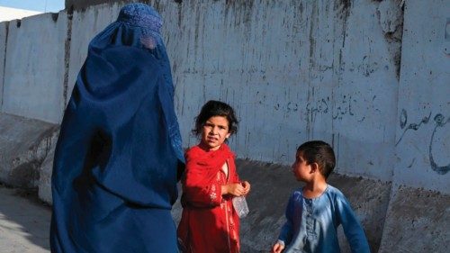 An Afghan burqa-clad woman walks with children, along a road in Kandahar on August 28, 2024. (Photo ... An Afghan burqa-clad woman walks with children, along a road in Kandahar on August 28, 2024. (Photo ...