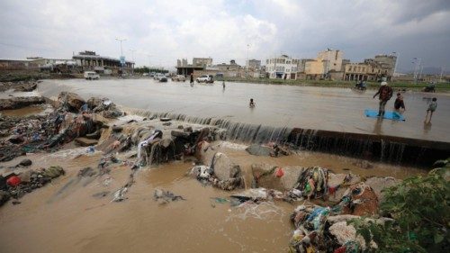 epa11569160 People walk through a flooded stream littered with waste caused by heavy rains, in ... epa11569160 People walk through a flooded stream littered with waste caused by heavy rains, in ...