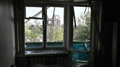 This photograph shows a destroyed building in background and seen trough a broken window of a ... This photograph shows a destroyed building in background and seen trough a broken window of a ...