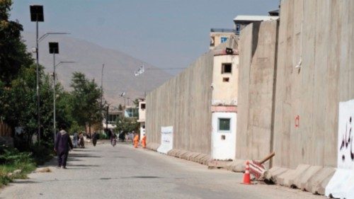 Afghan men walk near the site a day after a suicide bomber triggered explosives in front of the ... Afghan men walk near the site a day after a suicide bomber triggered explosives in front of the ...