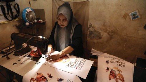 epaselect epa11573049 A Muslim worker sews tote bags with the image of Pope Francis at a workshop of ...