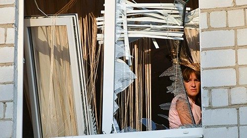 epaselect epa11583441 A woman looks through the broken window of her damaged flat at the site of a ... epaselect epa11583441 A woman looks through the broken window of her damaged flat at the site of a ...