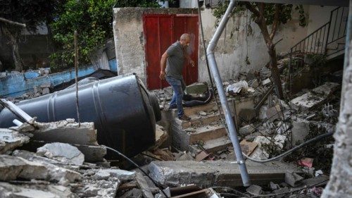 EDITORS NOTE: Graphic content / A resident checks the damage in the yard of a house, following an ... EDITORS NOTE: Graphic content / A resident checks the damage in the yard of a house, following an ...