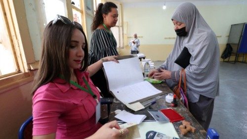 TOPSHOT - Algerian electoral officials check the identification of a voter at a polling station ... TOPSHOT - Algerian electoral officials check the identification of a voter at a polling station ...