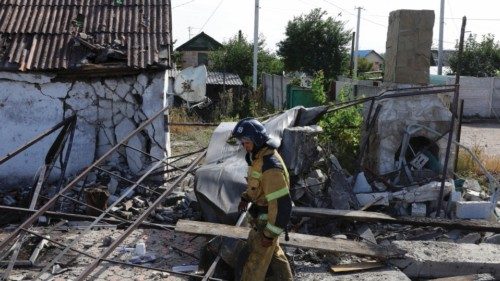 A firefighter works in the yard of a destroyed house following the shelling, which local ... A firefighter works in the yard of a destroyed house following the shelling, which local ...