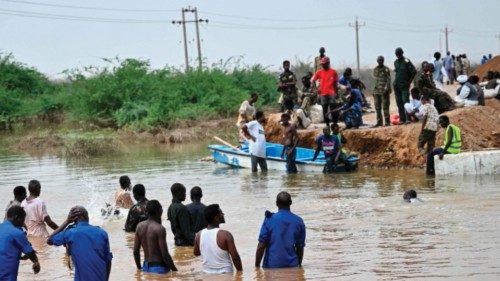Sudanese army soldiers look on as people use a boat in an inundated area in Tokar in the Red Sea ... Sudanese army soldiers look on as people use a boat in an inundated area in Tokar in the Red Sea ...