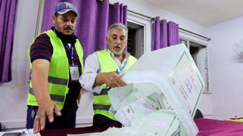 Electoral staff members empty a ballot box at a polling station after voting ended during ... Electoral staff members empty a ballot box at a polling station after voting ended during ...