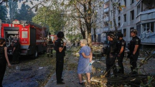 epa11606350 Local people and police officers stand near the site of a damaged residential building ... epa11606350 Local people and police officers stand near the site of a damaged residential building ...