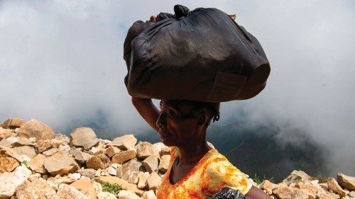 TOPSHOT - A woman carries her belongings on her head as she leaves Port-au-Prince to take refuge in ... TOPSHOT - A woman carries her belongings on her head as she leaves Port-au-Prince to take refuge in ...