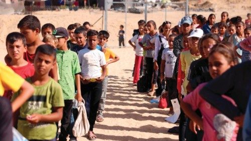 Palestinian school children queue up at a temporary educational centre under the supervision and ... Palestinian school children queue up at a temporary educational centre under the supervision and ...