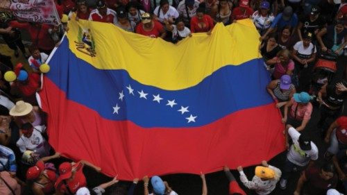 Government supporters hold a Venezuelan flag during a march to celebrate two months of President ... Government supporters hold a Venezuelan flag during a march to celebrate two months of President ...