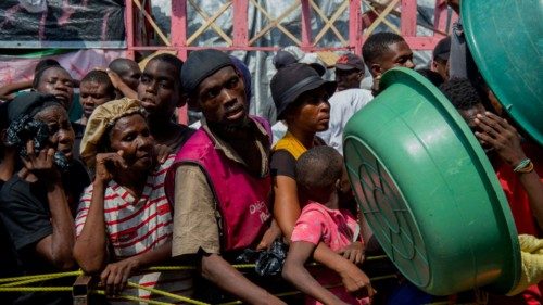 TOPSHOT - People wait for a food distribution in a displaced persons camp at the Lycée Marie Jeanne ... TOPSHOT - People wait for a food distribution in a displaced persons camp at the Lycée Marie Jeanne ...