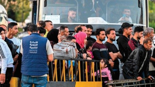 People fleeing from Lebanon arrive on the Syrian side of the border with Lebanon in Jdeidat Yabus in ...