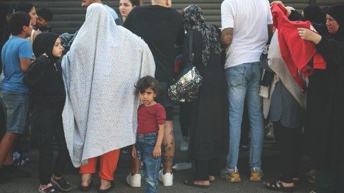 Displaced families get clothes outside the famous Skybar club, which became a shelter for the ...