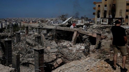 A man stands amid the damage caused by Israeli airstrikes, as smokes rises over Beirut southern ... A man stands amid the damage caused by Israeli airstrikes, as smokes rises over Beirut southern ...