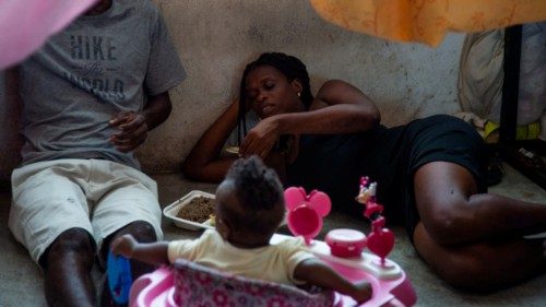 A family eats after a food distribution in a displaced persons camp at the Lycée Marie Jeanne school ... A family eats after a food distribution in a displaced persons camp at the Lycée Marie Jeanne school ...