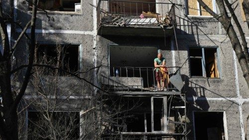 A local resident stands on a balcony of a residential building, damaged following an overnight ... A local resident stands on a balcony of a residential building, damaged following an overnight ...