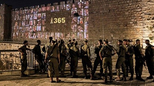 Israeli army soldiers stand by as a yellow ribbon along with the number 365, signifying the number ... Israeli army soldiers stand by as a yellow ribbon along with the number 365, signifying the number ...