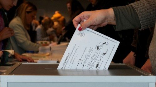 A voter casts a ballot into the box during early voting in the Lithuanian general elections, in ... A voter casts a ballot into the box during early voting in the Lithuanian general elections, in ...