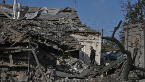 A man stands next to his house destroyed by a Russian air strike, amid Russia's attack on Ukraine, ...