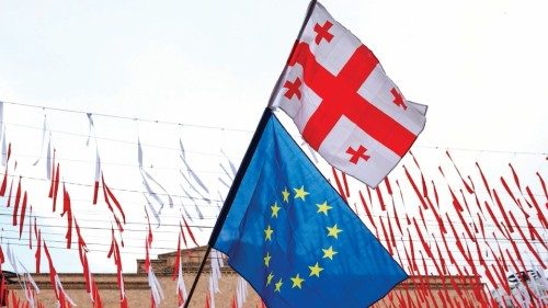 (FILES) A protester waves a Georgian national (top) and a European Union flags as he protests the ... (FILES) A protester waves a Georgian national (top) and a European Union flags as he protests the ...